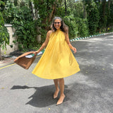 The Amalfi Halter Dress in golden ochre, skirt in motion showing the full swing silhouette