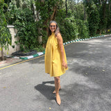 The Amalfi Halter Dress in golden ochre, side profile view