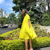 The Daisy Flared Dress in citron yellow captured in motion, showing the flared swing skirt