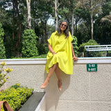 The Daisy Flared Dress in citron yellow styled with nude heels, seated pose