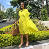The Daisy Flared Dress in citron yellow styled with a tan tote bag and nude heels